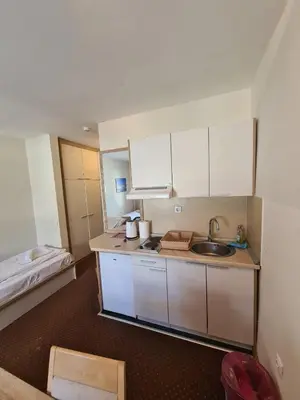 a small kitchen with a sink and a bed at Centar slope 4 apartman in Kopaonik