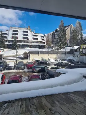 a group of cars parked in a parking lot with snow at Centar slope 4 apartman in Kopaonik