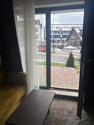 a living room with a door open to a street at Apartman u hotelu Harmonija Palace Kopaonik in Kopaonik