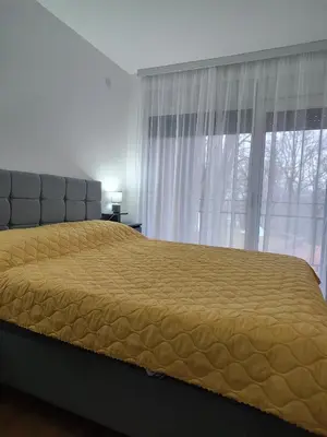 a bedroom with a bed with a yellow bedspread at D&D Apartment in Vrnjačka Banja