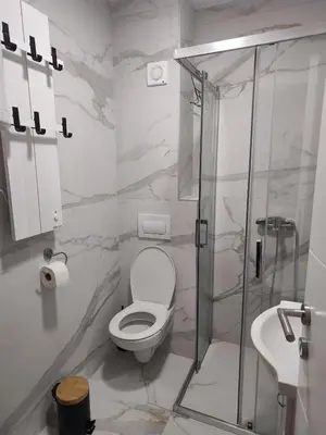 a bathroom with a toilet and a glass shower at D&D Apartment in Vrnjačka Banja