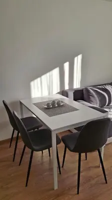a table and chairs in a living room with a couch at Apartmani Maša Kopaonik in Kopaonik