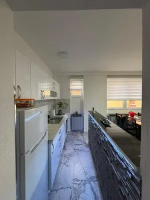 a kitchen with white cabinets and a counter top at Apartman AURORA Trstenik in Trstenik
