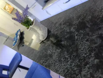a vase with purple flowers sitting on a table at Apartman AURORA Trstenik in Trstenik