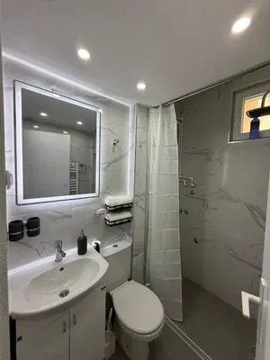 a bathroom with a sink and a toilet and a mirror at Apartman AURORA Trstenik in Trstenik
