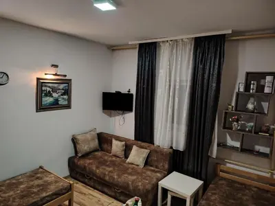 a living room with a couch and a window at Ski in ski out Apartman in Kopaonik