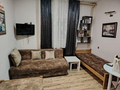 a living room with a couch and a window at Ski in ski out Apartman in Kopaonik
