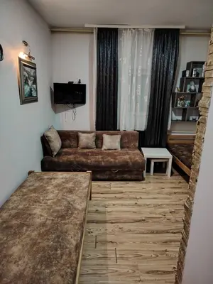 a living room with a couch and a tv at Ski in ski out Apartman in Kopaonik