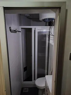 a small bathroom with a shower and a toilet at Ski in ski out Apartman in Kopaonik