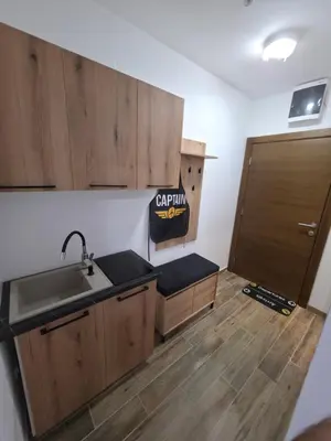 a kitchen with wooden cabinets and a sink and a door at Pilot peak in Kopaonik