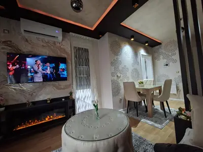 a living room with a fireplace and a tv at Royal Lux in Vrnjačka Banja