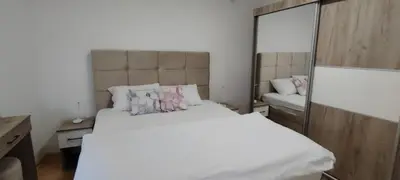 a bedroom with a large white bed and a mirror at Apartman CiricMDV in Vrnjci
