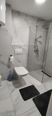 a bathroom with a shower and a toilet and a sink at Apartman CiricMDV in Vrnjci