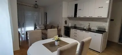 a kitchen and living room with a table and chairs at Apartman CiricMDV in Vrnjci