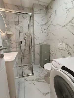 a bathroom with a shower and a toilet and a sink at Central lux in Ćuprija