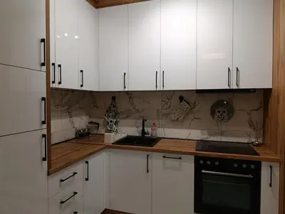 a kitchen with white cabinets and a sink at Central lux in Ćuprija