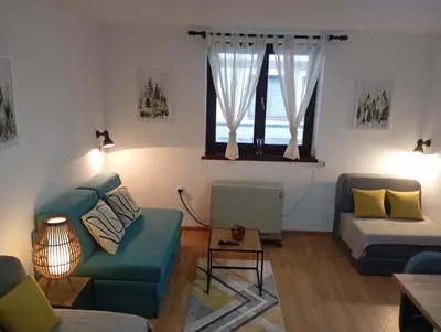 a living room with a blue couch and a table at Gondola Lux Apartment in Brzeće