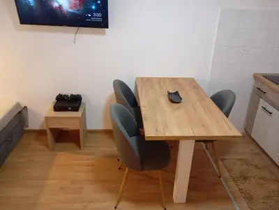 a wooden table with chairs and a computer mouse on it at Gondola Lux Apartment in Brzeće