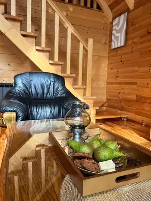 a living room with a glass table and a couch at Kaizen Cabin in Kursumlijska Banja