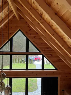a room with a large window in a wooden ceiling at Kaizen Cabin in Kursumlijska Banja