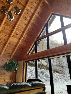 a large window in a room with a leather couch at Kaizen Cabin in Kursumlijska Banja