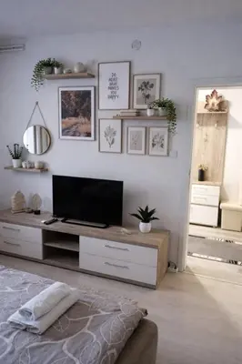 a bedroom with a tv on a white wall at Apartmani NANA in Vrnjci