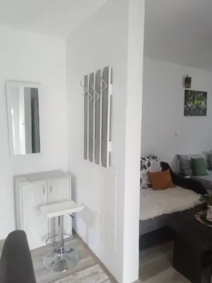 a white living room with a couch and a table at Apartmani NANA in Vrnjci