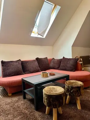 a living room with a red couch and a table at Chalet Pinecone - Ušuškan apartman, savršen za zimu i leto - Modern Mountain Retreat with Stunning View in Kopaonik