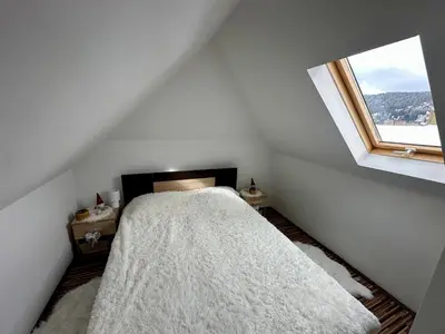 a white bedroom with a bed and a window at Chalet Pinecone - Ušuškan apartman, savršen za zimu i leto - Modern Mountain Retreat with Stunning View in Kopaonik