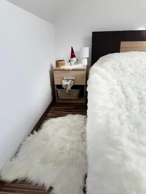 a bedroom with two white furry rugs on the floor at Chalet Pinecone - Ušuškan apartman, savršen za zimu i leto - Modern Mountain Retreat with Stunning View in Kopaonik