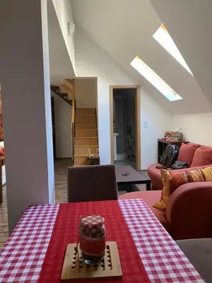 a living room with a table with a red and white checkered table cloth at Chalet Pinecone - Ušuškan apartman, savršen za zimu i leto - Modern Mountain Retreat with Stunning View in Kopaonik