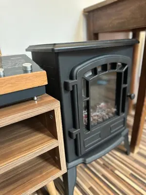 a black wood stove in a room with wooden shelves at Chalet Pinecone - Ušuškan apartman, savršen za zimu i leto - Modern Mountain Retreat with Stunning View in Kopaonik