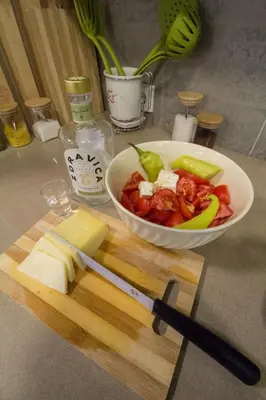a bowl of food on a cutting board with a knife at Kuća Knjiga in Slavinja