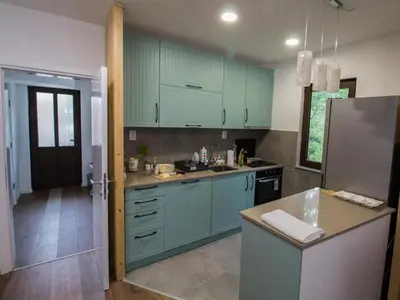 a kitchen with green cabinets and a counter top at Kuća Knjiga in Slavinja