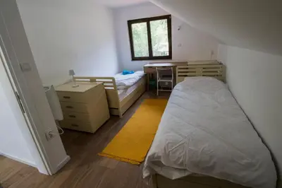 a bedroom with a bed and a desk and a table at Kuća Knjiga in Slavinja