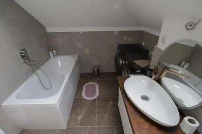 a bathroom with a sink and a tub and a toilet and a bath tub at Kuća Knjiga in Slavinja
