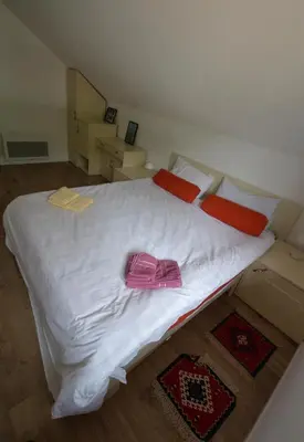 a large white bed with a pink purse on it at Kuća Knjiga in Slavinja