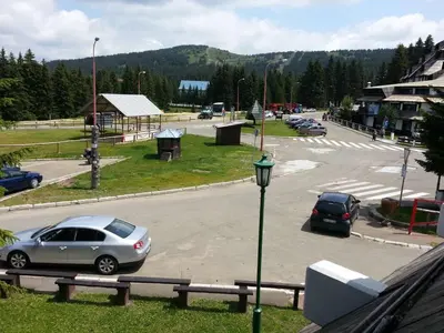 a street with cars parked in a parking lot at Apartment Brvenik Plus in Kopaonik