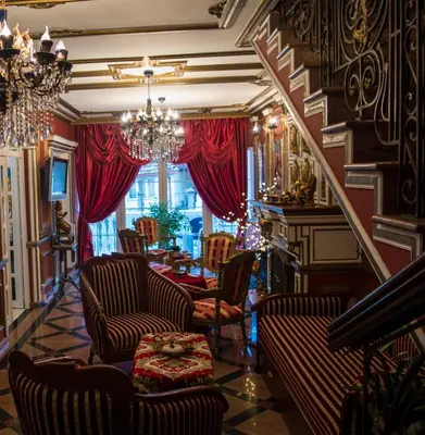 a living room with chairs and a chandelier at Apartmani Vivaldi Niš in Niš