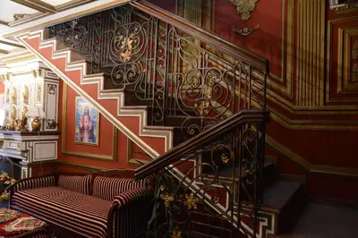 a room with a staircase with a couch and a stair case at Apartmani Vivaldi Niš in Niš