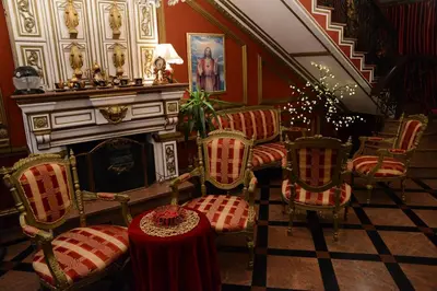 a room with chairs and a fireplace and a table at Apartmani Vivaldi Niš in Niš
