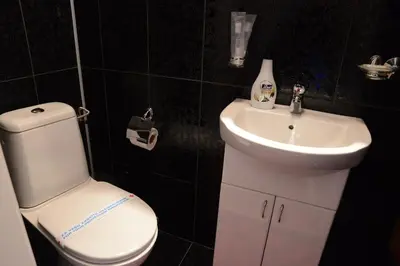 a bathroom with a white toilet and a sink at Apartmani Vivaldi Niš in Niš