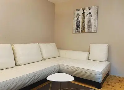 a living room with a white couch and a table at Holiday Home Aleksandar Brzece Kopaonik in Brzeće