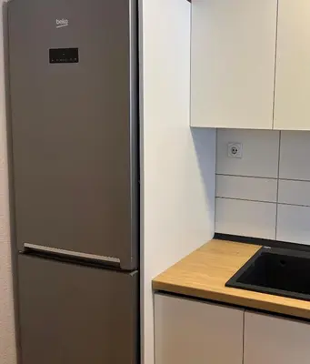 a stainless steel refrigerator in a kitchen next to a counter at Holiday Home Aleksandar Brzece Kopaonik in Brzeće