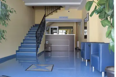 a hallway with blue chairs and stairs in a hospital at Smeštaj Franica in Kuršumlija