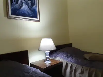 a lamp sitting on a table next to two beds at Smeštaj Franica in Kuršumlija