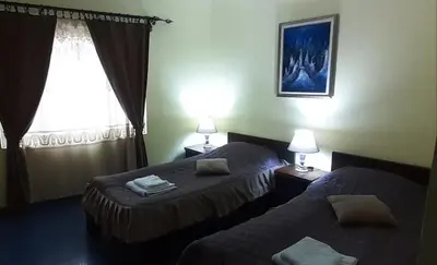 a hotel room with two beds and a window at Smeštaj Franica in Kuršumlija