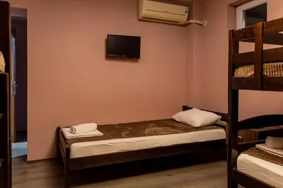 a small room with a bunk bed and a television at Guest House Vila Salute in Niš