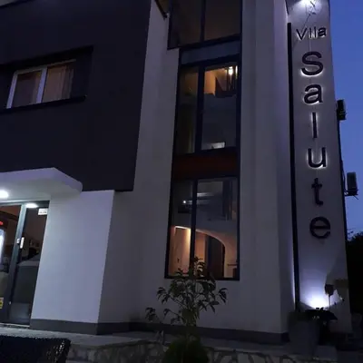 a black and white building with a sign on it at Guest House Vila Salute in Niš