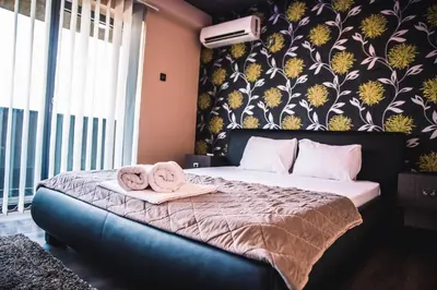 a bedroom with a bed with towels on it at Guest House Vila Salute in Niš